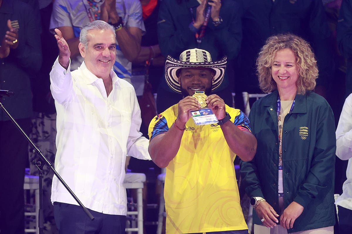 El presidente de República Dominicana, Luis Abinader (i), premia al pesista de Colombia Yeison López (c) por batir récord en los Juegos Centroamericanos y del Caribe Santo Domingo 2026. //Foto, EFE: Orlando Barría