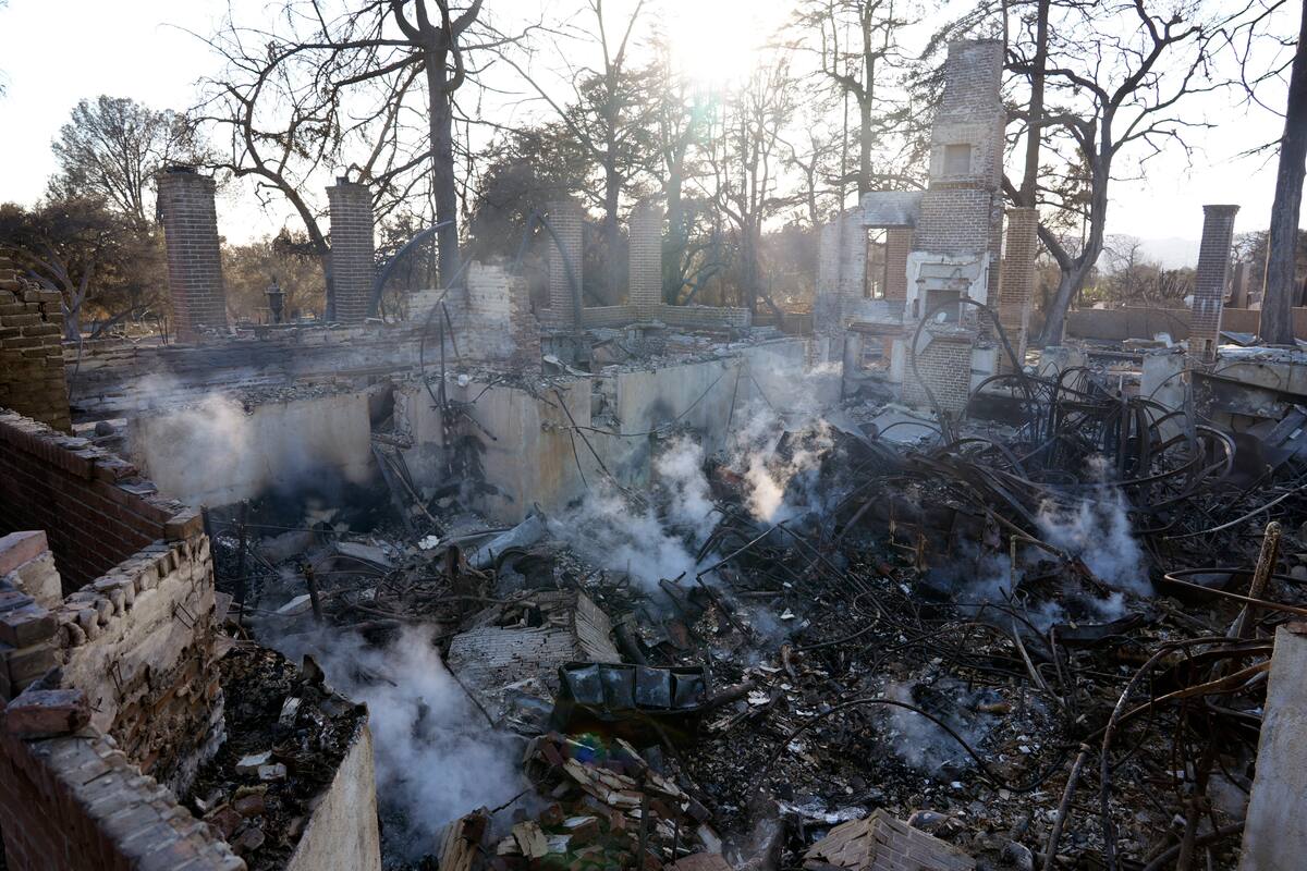 El humo se eleva desde los restos carbonizados de una estructura en el campus de la Escuela Waldorf de Pasadena, en Altadena (California). //Chris Pizzello - AP