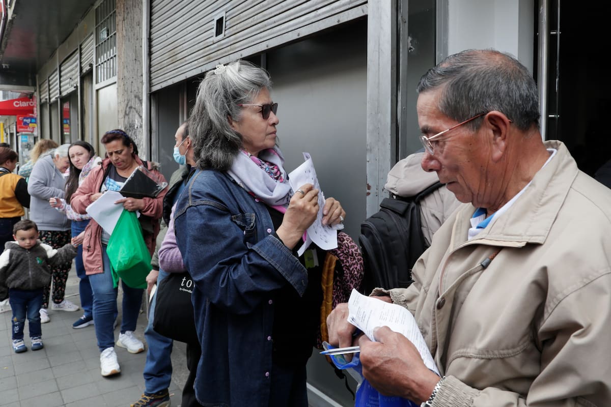 Personas hacen fila para reclamar medicamentos en la cadena de droguerías Audifarma este viernes, en Bogotá (Colombia). EFE/ Carlos Ortega