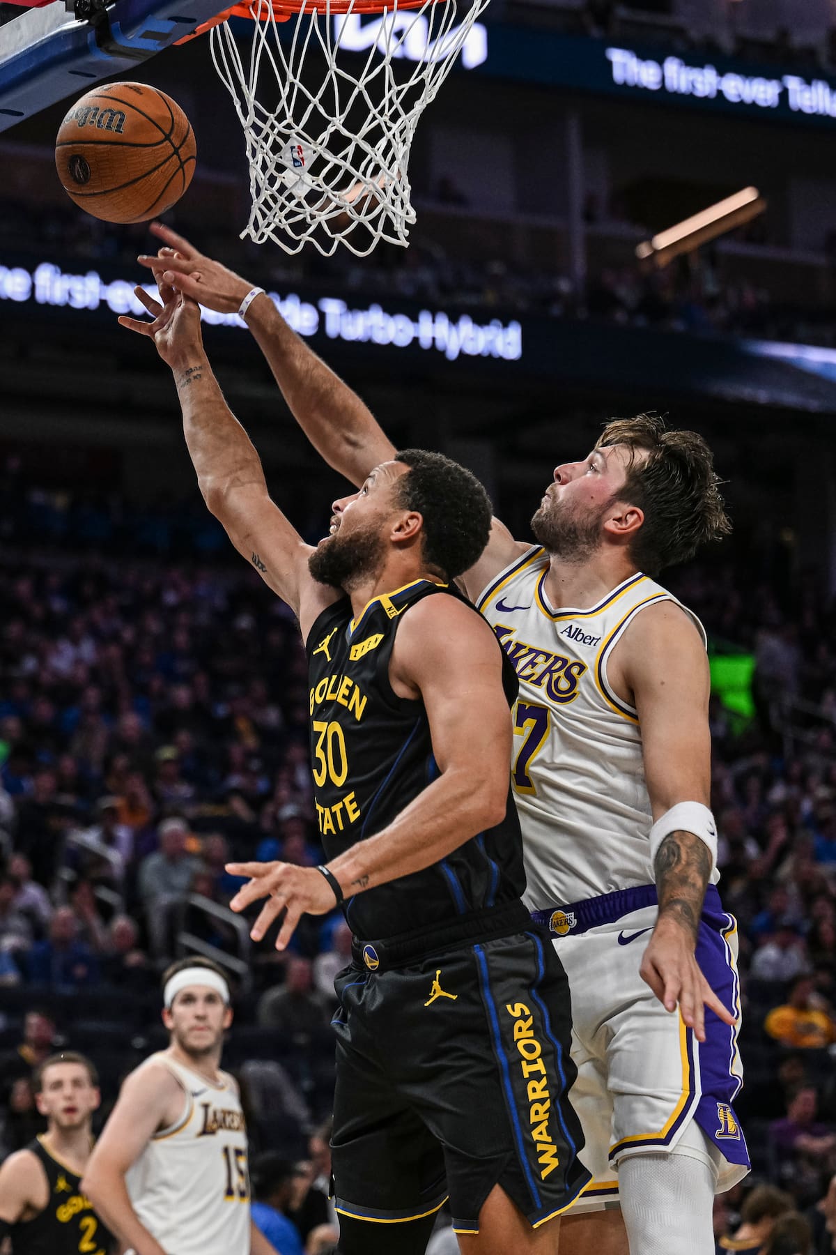 El escolta de los Los Angeles Lakers, Luka Doncic (77), bloquea al escolta de los Golden State Warriors, Stephen Curry (30), durante la segunda mitad de un partido de la NBA Cup. //Foto, AP: Justine Willard