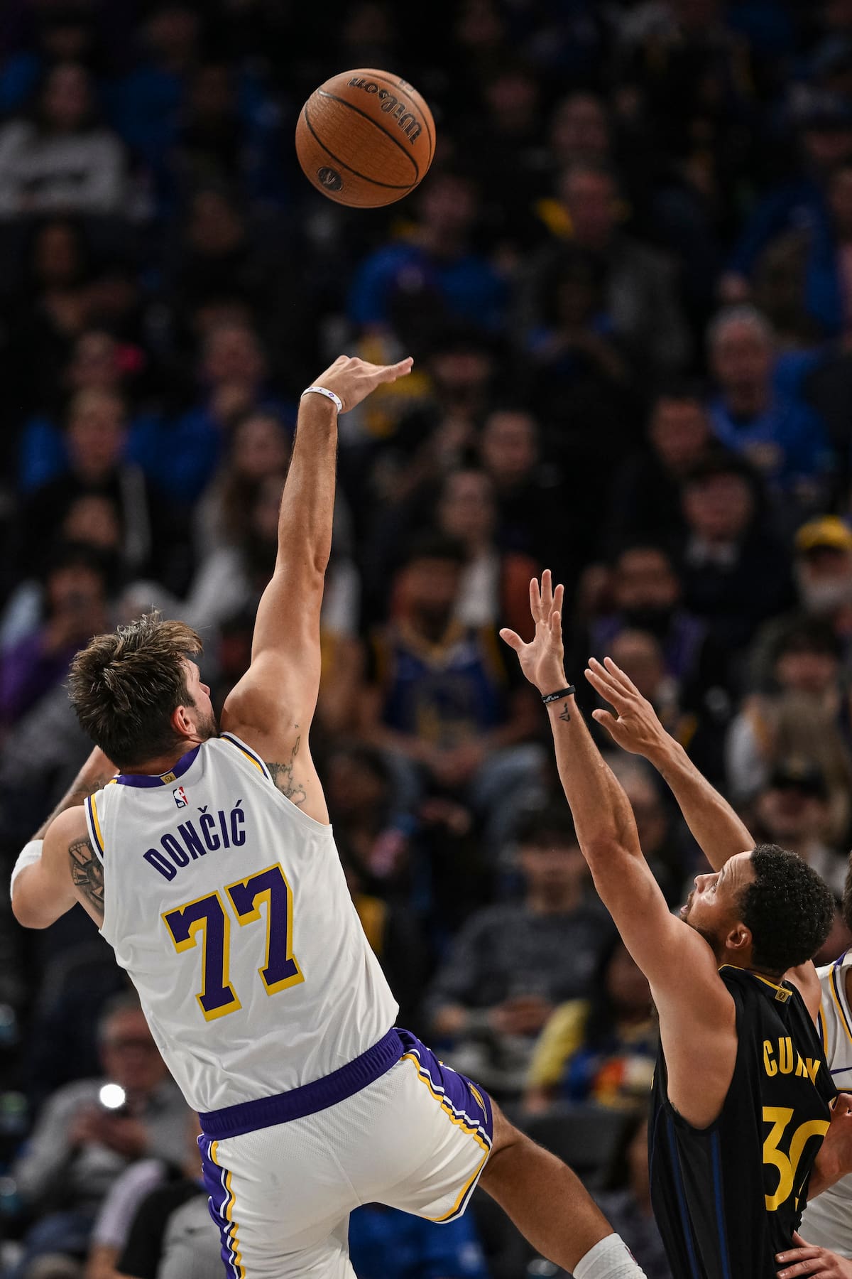 El jugador de los Los Angeles Lakers, Luka Doncic (77), realiza un tiro por encima del jugador de los Golden State Warriors, Stephen Curry (30), durante la segunda mitad de un partido de la NBA Cup. //Foto, AP: Justine Willard
