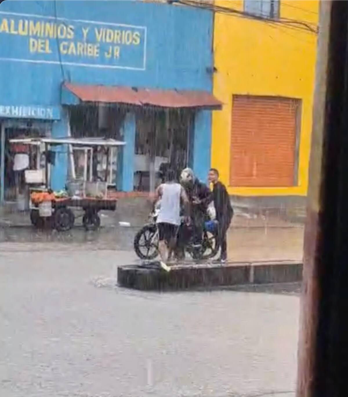 Estos rateros atracan en pleno aguacero a un hombre que se desplaza en una motocicleta por el Centro de Barranquilla//Cortesía.