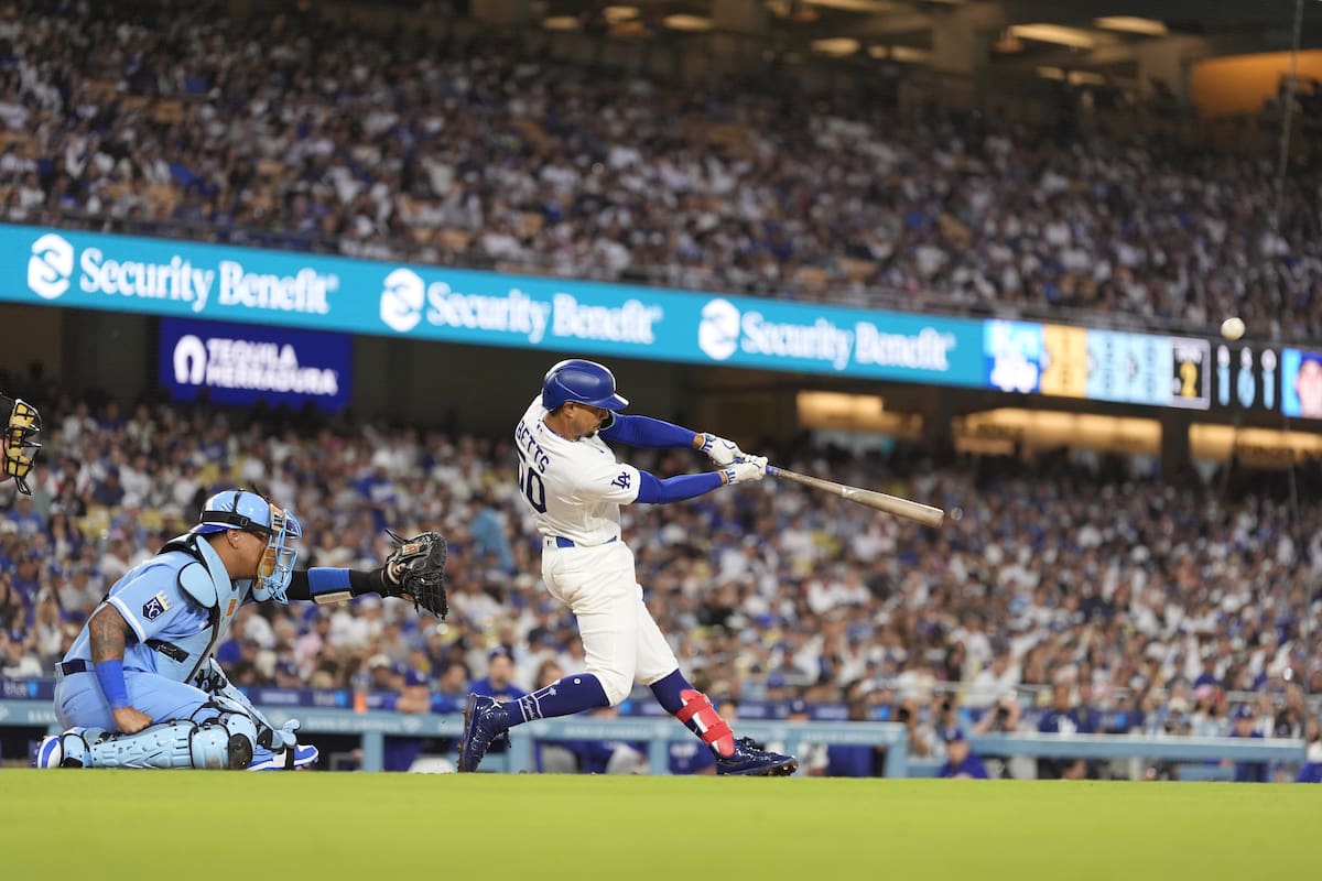 Mookie Betts, de los Dodgers de Los Ángeles, batea un jonrón solitario delante del catcher venezolano Salvador Pérez, de los Reales de Kansas City. //Foto, AP: Mark J. Terrill