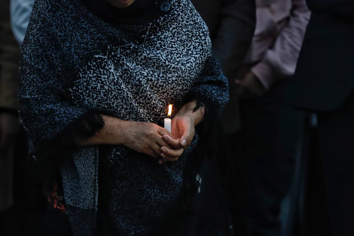 Una mujer porta una vela en referencia al luto por la muerte de estudiantes en Brasil. // Colprensa.