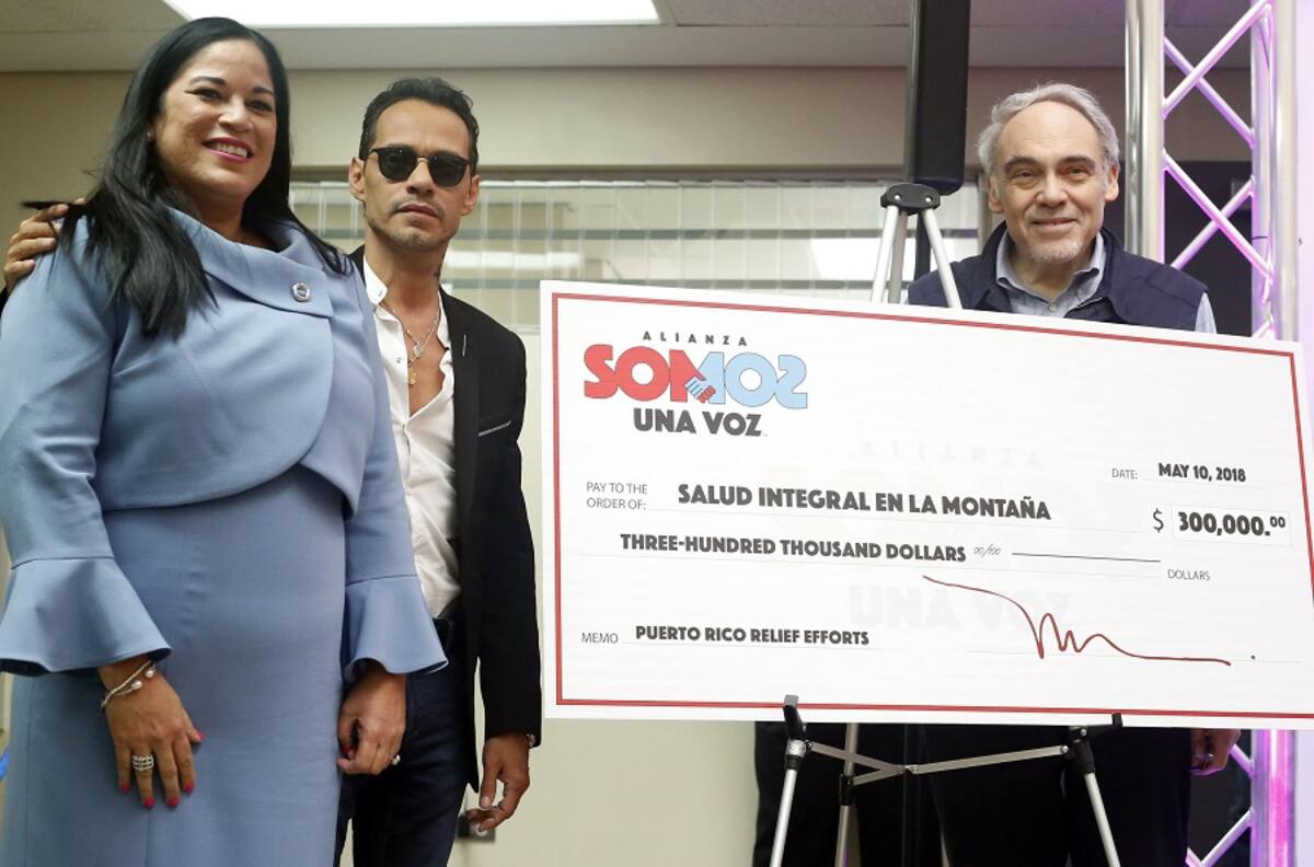 El cantante estadounidense de padres puertorriqueños, Marc Anthony (c), posa acompañado por la directora ejecutiva del ente puertorriqueño Salud Integral en la Montaña (SIM), Gloria Del Carmen Amador (i), y el el presidente emérito y cofundador de The Children's Health Fund (CHF), Irwin Redlener (d), con el cheque de 300 mil dólares que donó junto a la clínica móvil hoy, jueves 10 de mayo de 2018, en Orocovis (Puerto Rico). EFE