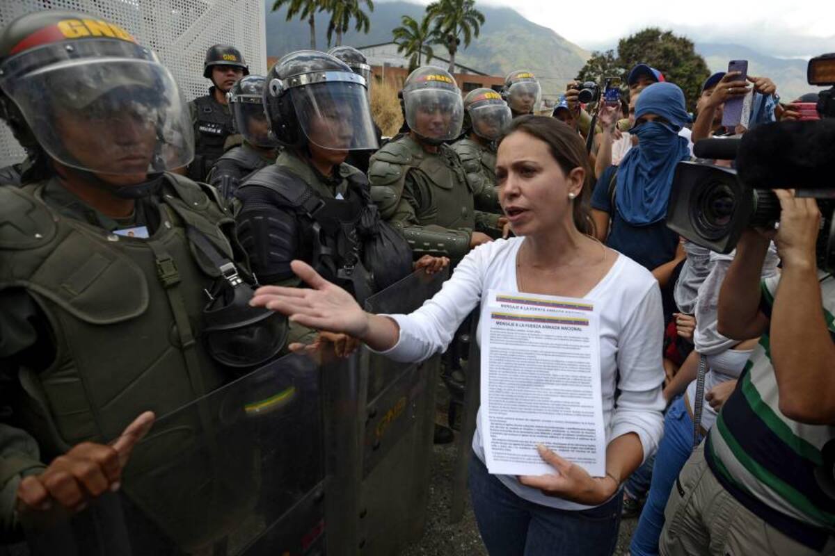 María Corina Machado habla con miembros de la Guardia Nacional durante una protesta contra el presidente venezolano Nicolás Maduro, en Caracas, el 16 de marzo de 2014. AFP PHOTO/JUAN BARRETO