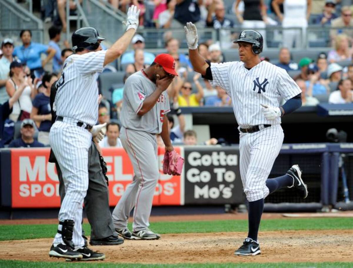 Mark Texeira y Alex Rodríaguez celebran la anotación de una carrera en el partido. AP Kathy Kmonicek