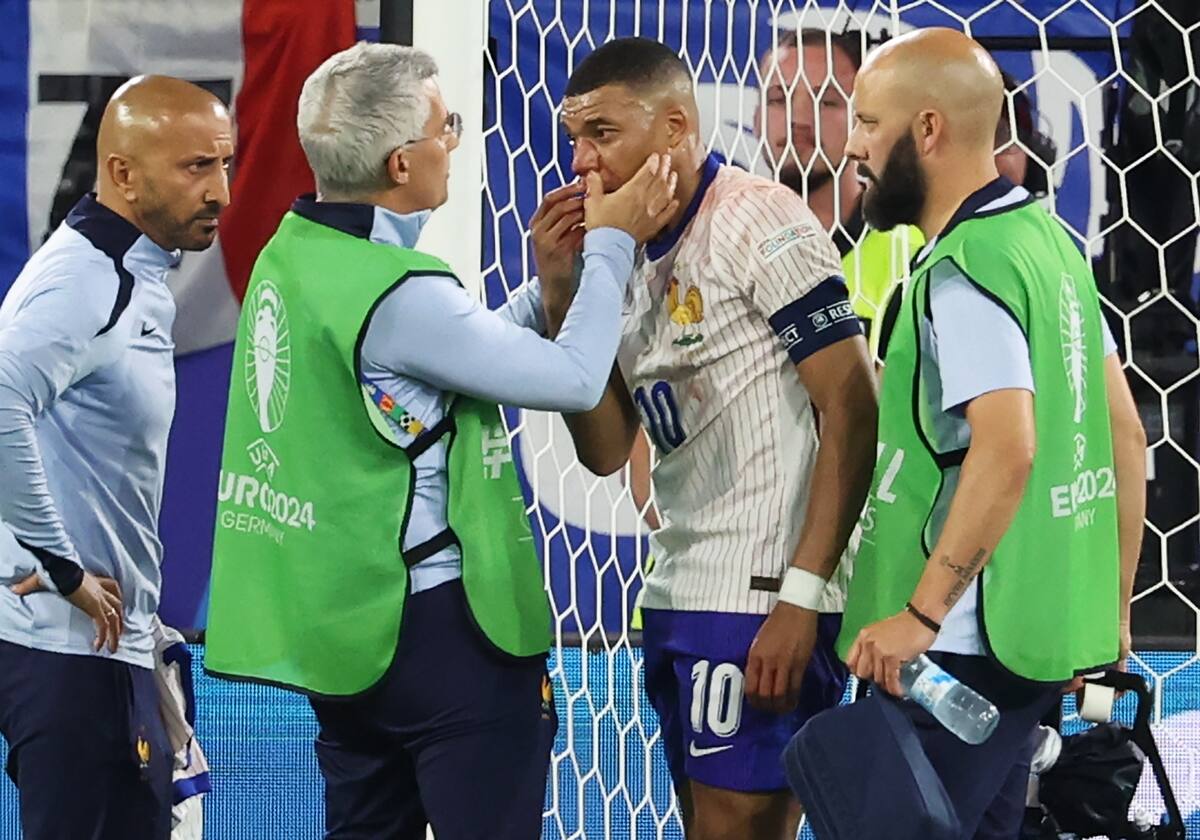 Kylian Mbappe (C) de Francia recibe atención médica durante el partido de fútbol del grupo D de la UEFA EURO 2024 entre Austria y Francia, en Dusseldorf, Alemania, el 17 de junio de 2024. //EFE