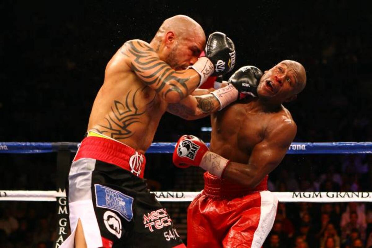 LAS VEGAS, NV - MAY 05: (L-R) Miguel Cotto connects with a left punch to the face of Floyd Mayweather Jr. during their WBA super welterweight title fight at the MGM Grand Garden Arena on May 5, 2012 in Las Vegas, Nevada. Al Bello/Getty Images/AFP== FOR NEWSPAPERS, INTERNET, TELCOS & TELEVISION USE ONLY ==