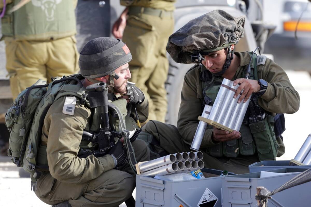 Soldados israelíes recargan las cápsulas de gases lacrimógenos para lanzarlas hacia los territorios palestinos en la frontera, al sur de Israe. EFE