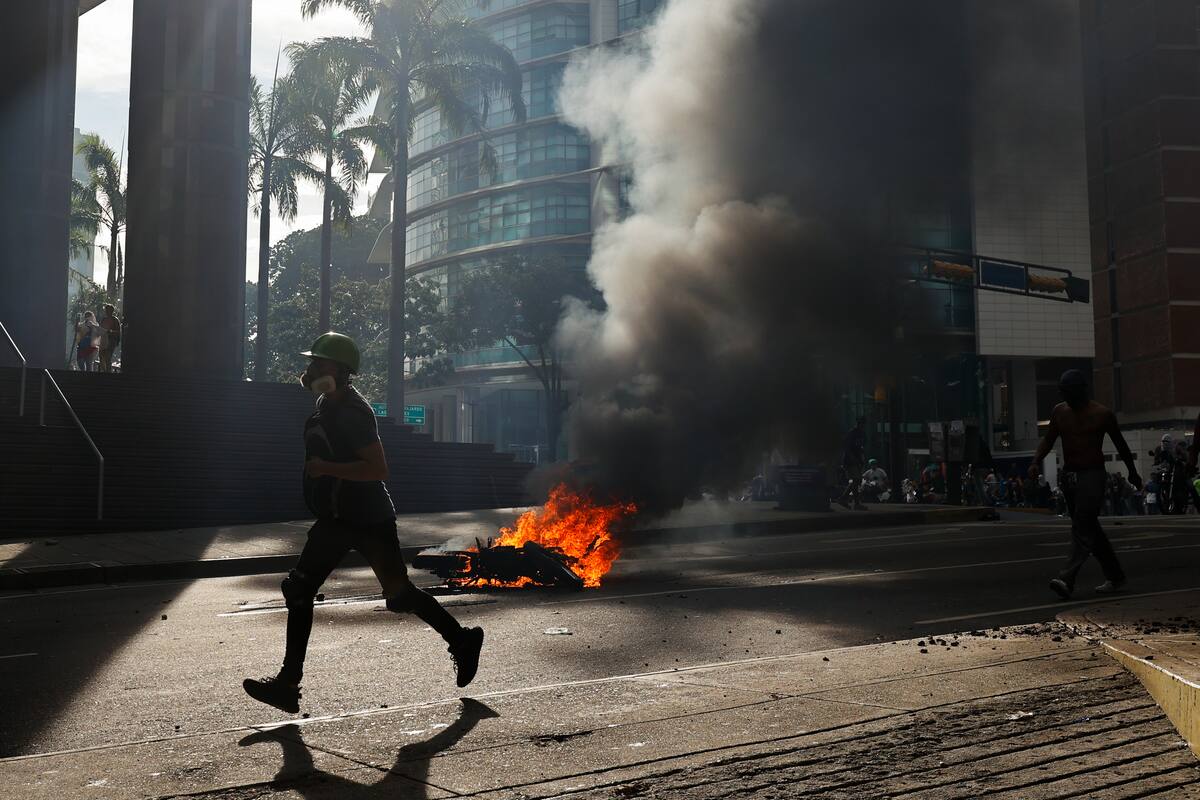 Un manifestante corre durante enfrentamientos entre opositores y miembros de la Guardia Nacional Bolivariana (GNB), por los resultados de las elecciones presidenciales Caracas, Venezuela. //EFE