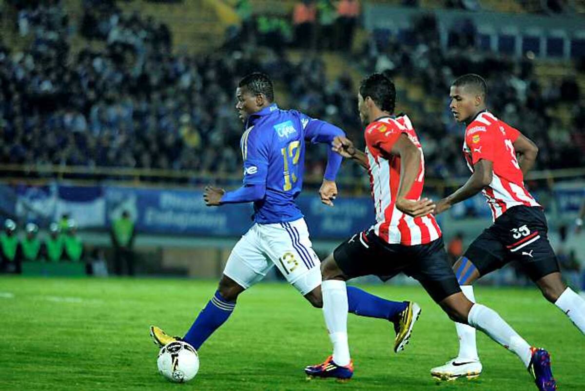 El jugador Jarol Martínez de Millonarios disputa el balón con el jugador Luis Carlos Ruiz de Junior durante el Partido entre los dos equipos por la semifinal de la Copa Postobón. COLPRENSA