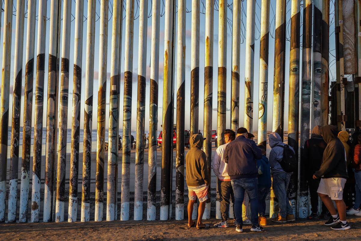 Un grupo de personas observan el rescate del cuerpo de un migrante de origen ruso, el 9 de noviembre de 2022 en la ciudad fronteriza de Tijuana, Baja California (México). //EFE