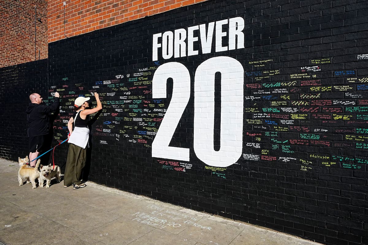 Aficionados firman un mural en el memorial al jugador del Liverpool Diogo Jota en Sybil Road en Anfield, Liverpool. //Foto, AP: Peter Byrne
