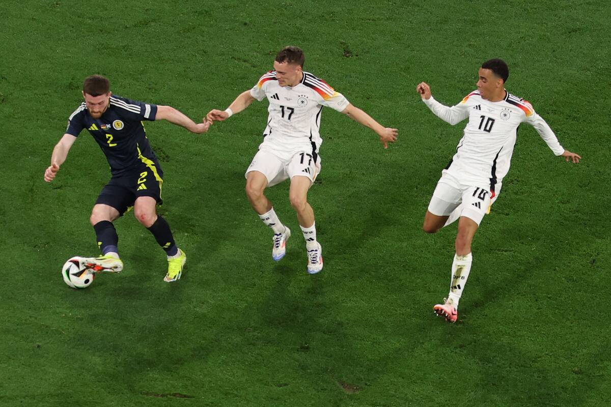 El jugador escocés Anthony Ralston en acción contra los alemanes Florian Wirtz y Jamal Musiala de Alemania durante el partido de la Eurocopa 2024 entre Alemania y Escocia en Munich, Alemania. //EFE