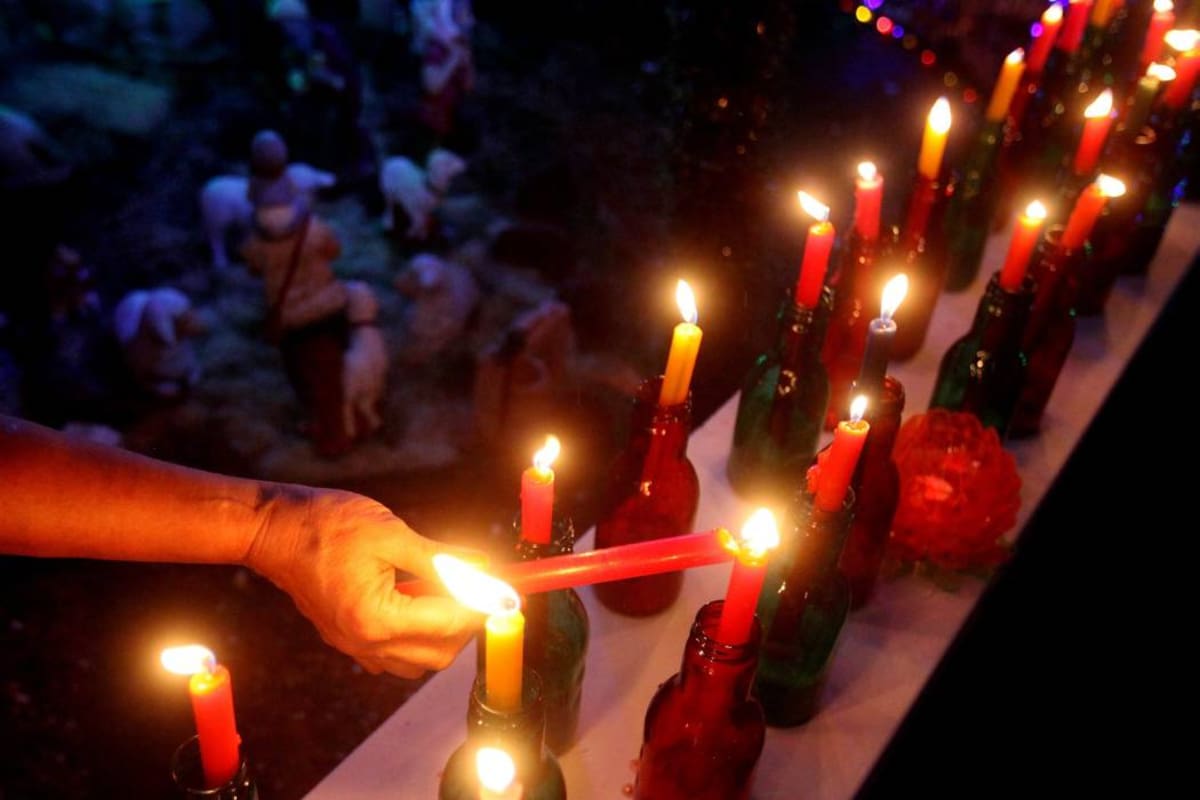 BOG02. MEDELLÍN (COLOMBIA), 07/12/2014.- Una mujer enciende velas durante la tradicional 'Noche de las Velitas' hoy, domingo 7 de diciembre de 2014, en Medellín (Colombia). La celebración se realiza en vísperas del Día de la Inmaculada Concepción y marca el comienzo de las fiestas de Navidad en el país. EFE/LUIS EDUARDO NORIEGA