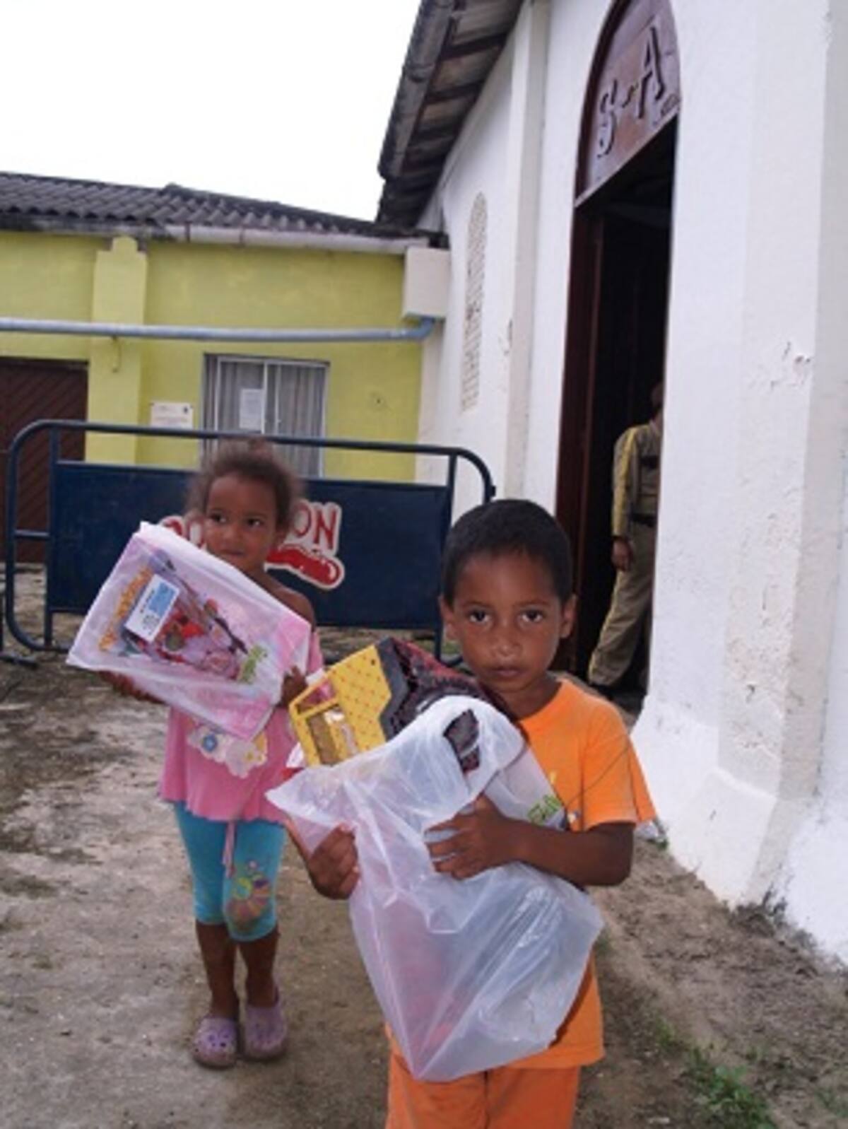 La felicidad de estos niños es evidente al salir de la iglesia con sus regalos