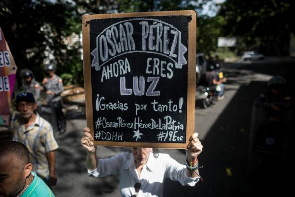Manifestante con pancarta alusiva a Óscar Pérez. EFE MIGUEL GUTIERREZ
