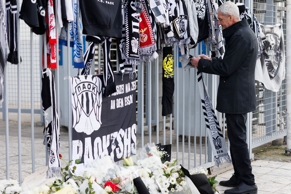 La gente enciende velas en memoria de los aficionados del PAOK que murieron en un accidente de tráfico en Rumania. //Foto, EFE: ACHILLEAS CHIRAS