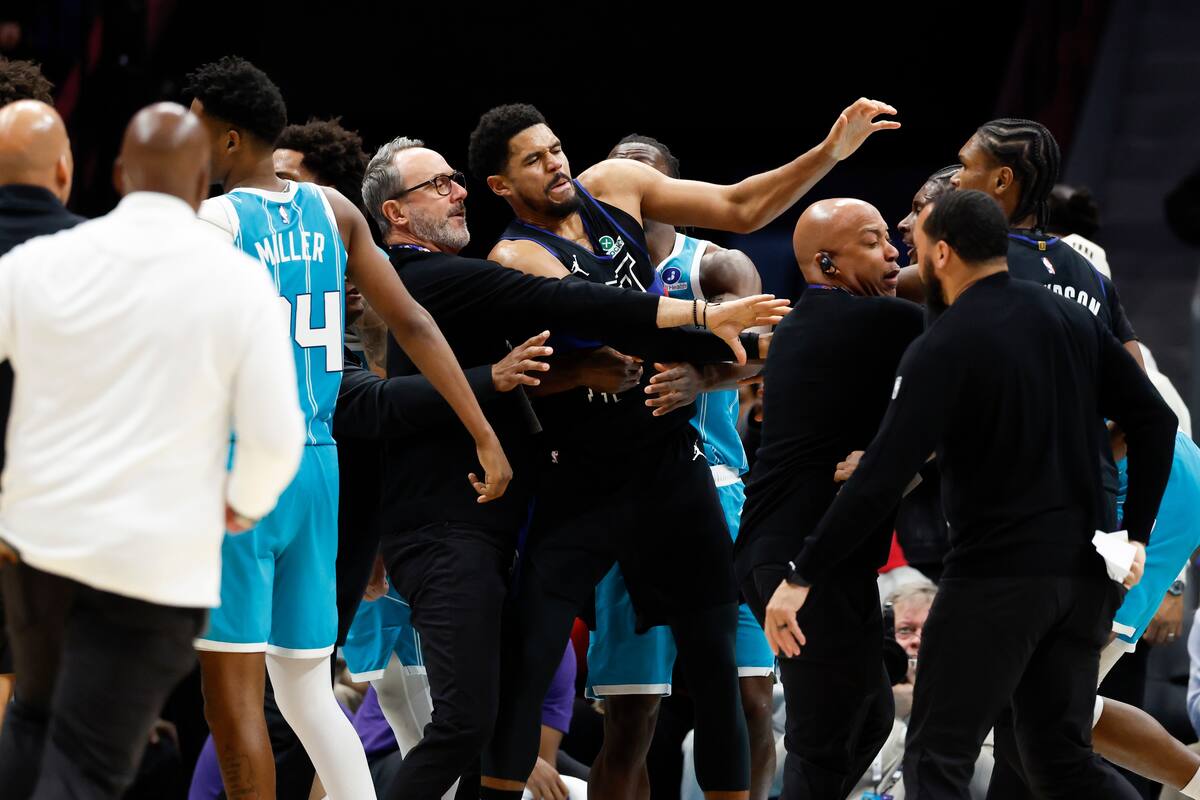 Los entrenadores y el personal de seguridad de los Charlotte Hornets y los Detroit Pistons intentan separar una pelea. //Foto, AP: Nell Redmond