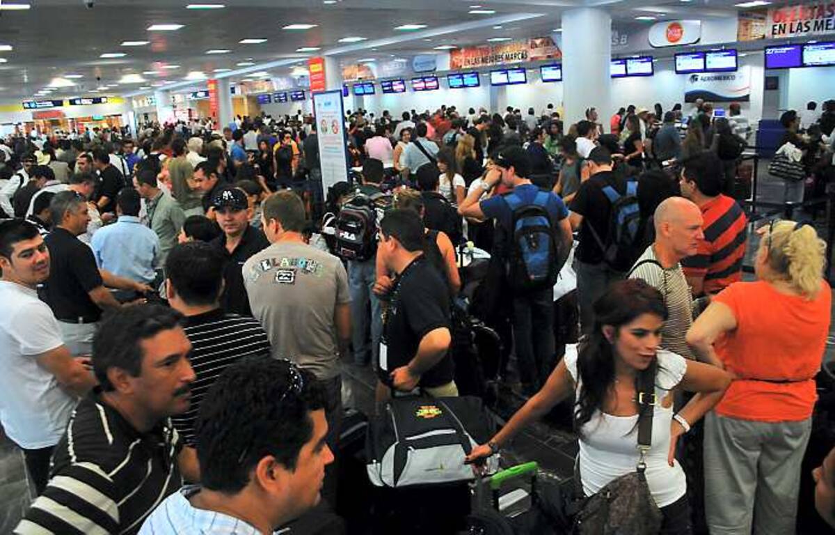 Largas colas serpenteaban hacia los estantes de boletos en el aeropuerto de Cancún mientras aviones de pasajeros con rumbo a Europa y Canadá esperaban bajo una lluvia intensa. AP Israel Leal