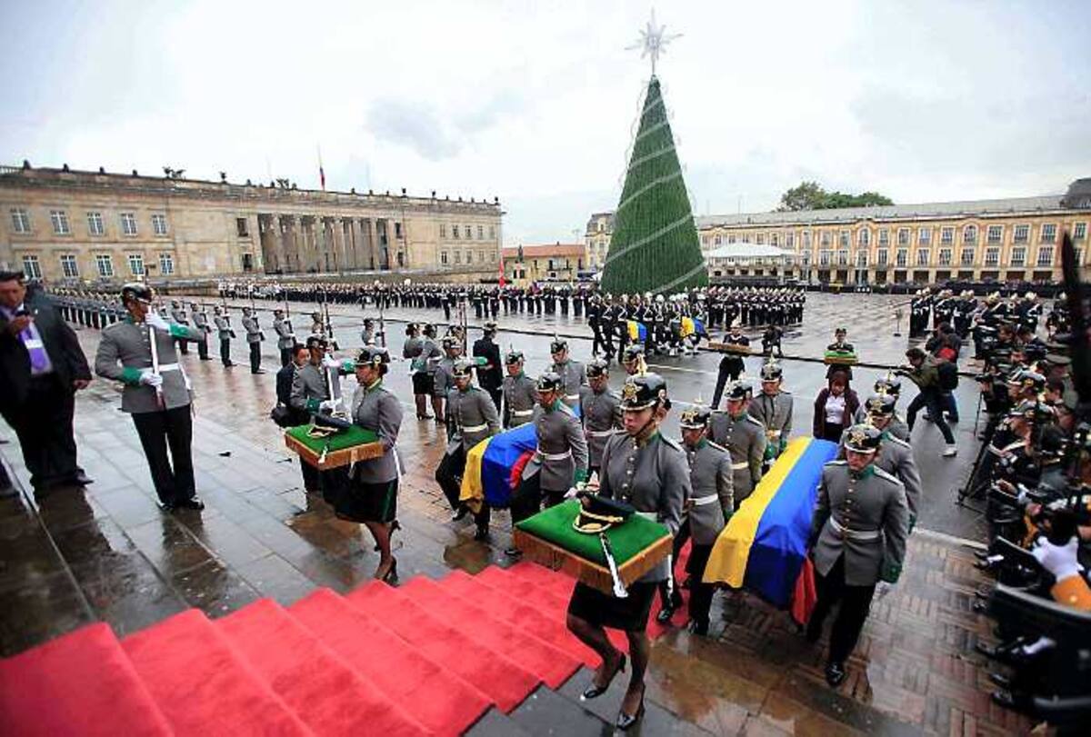 Agentes de policía llevan el ataúd con los restos de cuatro rehenes que fueron asesinados tras más de 10 años de secuestro por parte de las Farc. AP Fernando Vergara