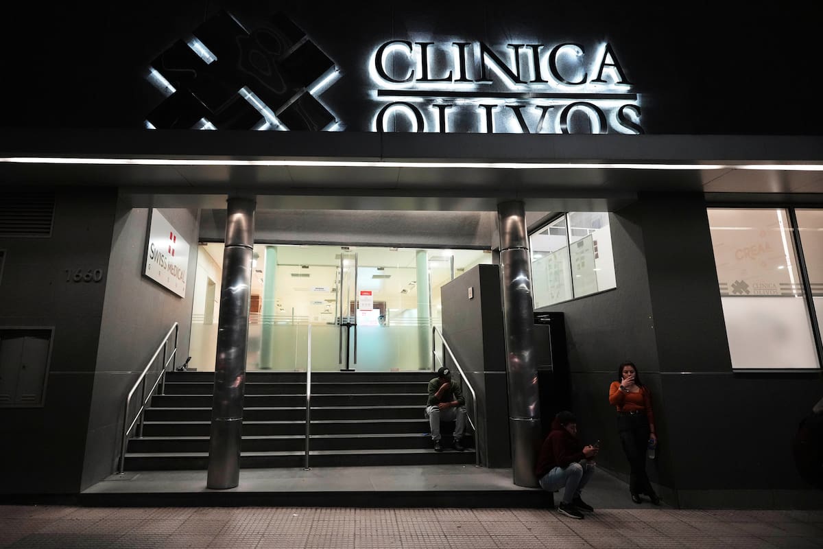 La gente se relaja afuera de la Clínica Olivos, donde la estrella del fútbol Diego Maradona fue operado semanas antes de su fallecimiento en 2020, en Buenos Aires. //AP