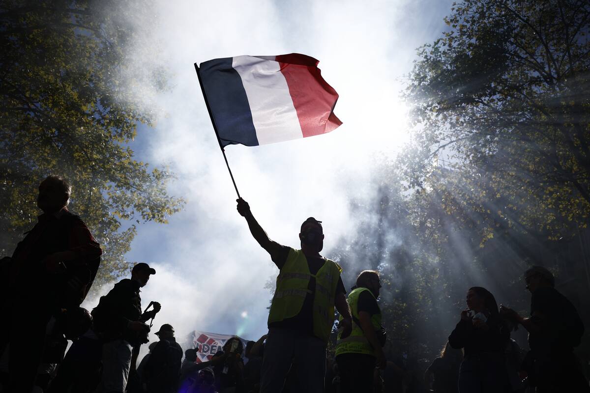 Un hombre agita una bandera francesa durante las protestas contra las medidas de austeridad en París. EFE/EPA/YOAN VALAT