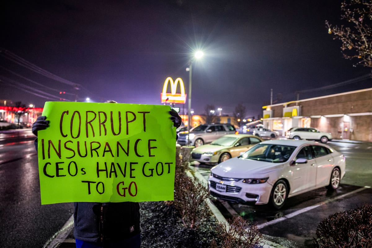 Una mujer, que no quiso ser identificada y que trabaja en la industria de la salud, sostiene un cartel de protesta afuera del restaurante McDonald's donde el Departamento de Policía de Altoona arrestó a Luigi Mangione. //EFE