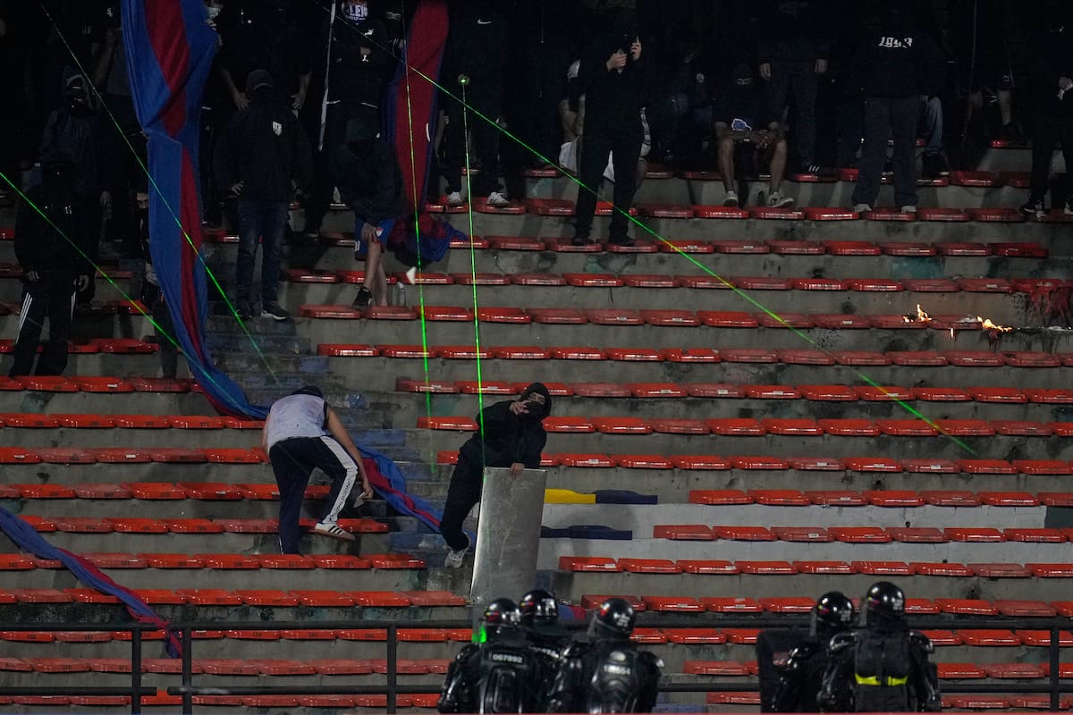 Hinchas de Independiente Medellín apuntan con señaladores láser hacia la cancha y obligan a la suspensión de un partido de la Copa Libertadores ante Flamengo. //Foto, AP: Fernando Vergara