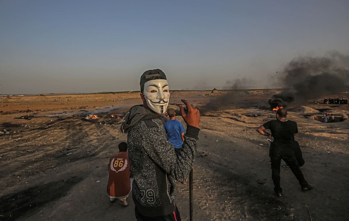 Un palestino protesta disfrazado con una máscara de Guy Fawkes durante las protestas cerca de la frontera entre Israel y Gaza, al este de Gaza City. EFE