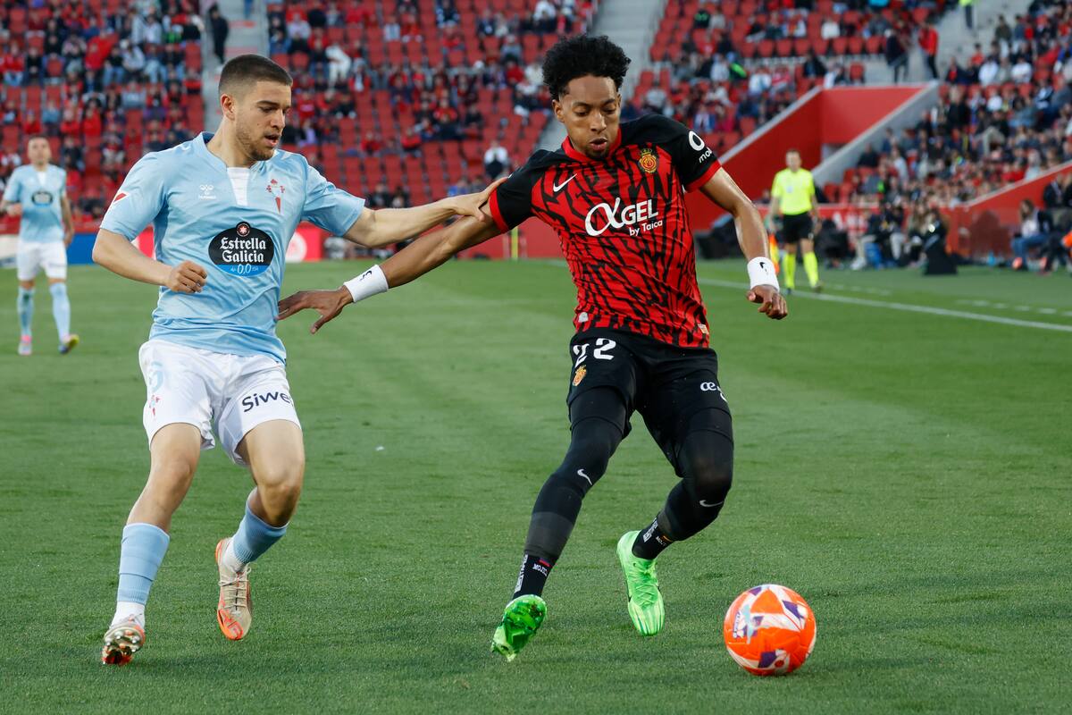 PALMA DE MALLORCA, 05/04/2025.- El defensa colombiano del Mallorca Johan Mojica (d) pelea un balón con el defensa del Celta Sergio Carreira durante el partido de LaLiga entre el Real Mallorca y el Celta, este sábado en el estadio de Son Moix, en Palma. EFE/CATI CLADERA