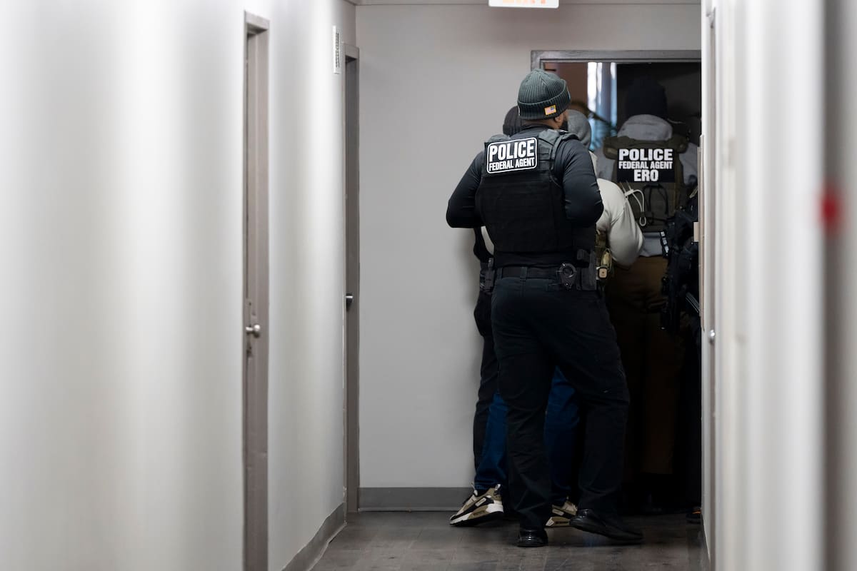 Agentes del Servicio de Control de Inmigración y Aduanas entran en una vivienda buscando a un sospechoso. //AP