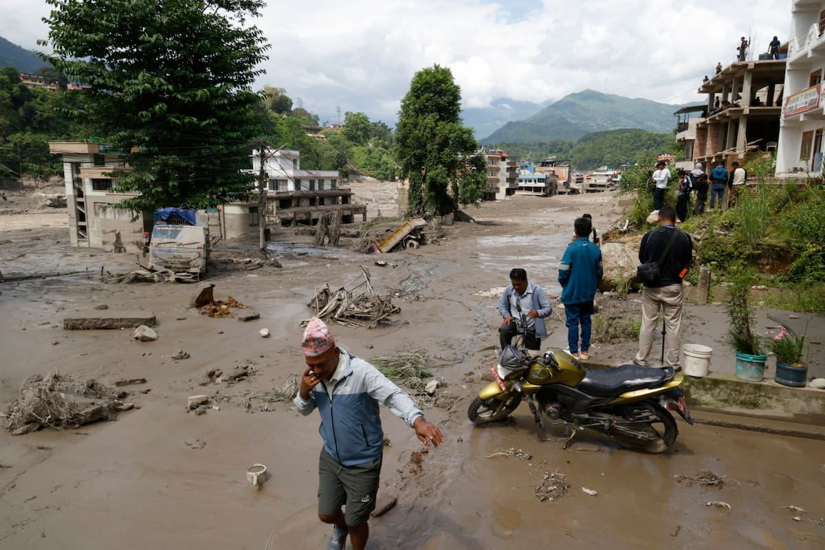 Campesinos avanzan entre el lodo en Trishuli, en el distrito nepalí de Nuwakot, tras una riada repentina. // Foto: EFE/EPA/NARENDRA SHRESTHA.