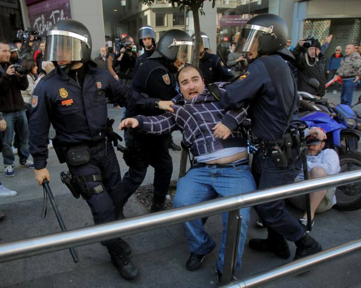 Riot police apprehend a protestor during a general strike in Madrid, Spain, Wednesday, Nov. 14, 2012. Spain's General Workers' Union said the nationwide stoppage, the second this year, was being observed by nearly all workers in the automobile, energy, shipbuilding and constructions industries. (AP Photo/Andres Kudacki)