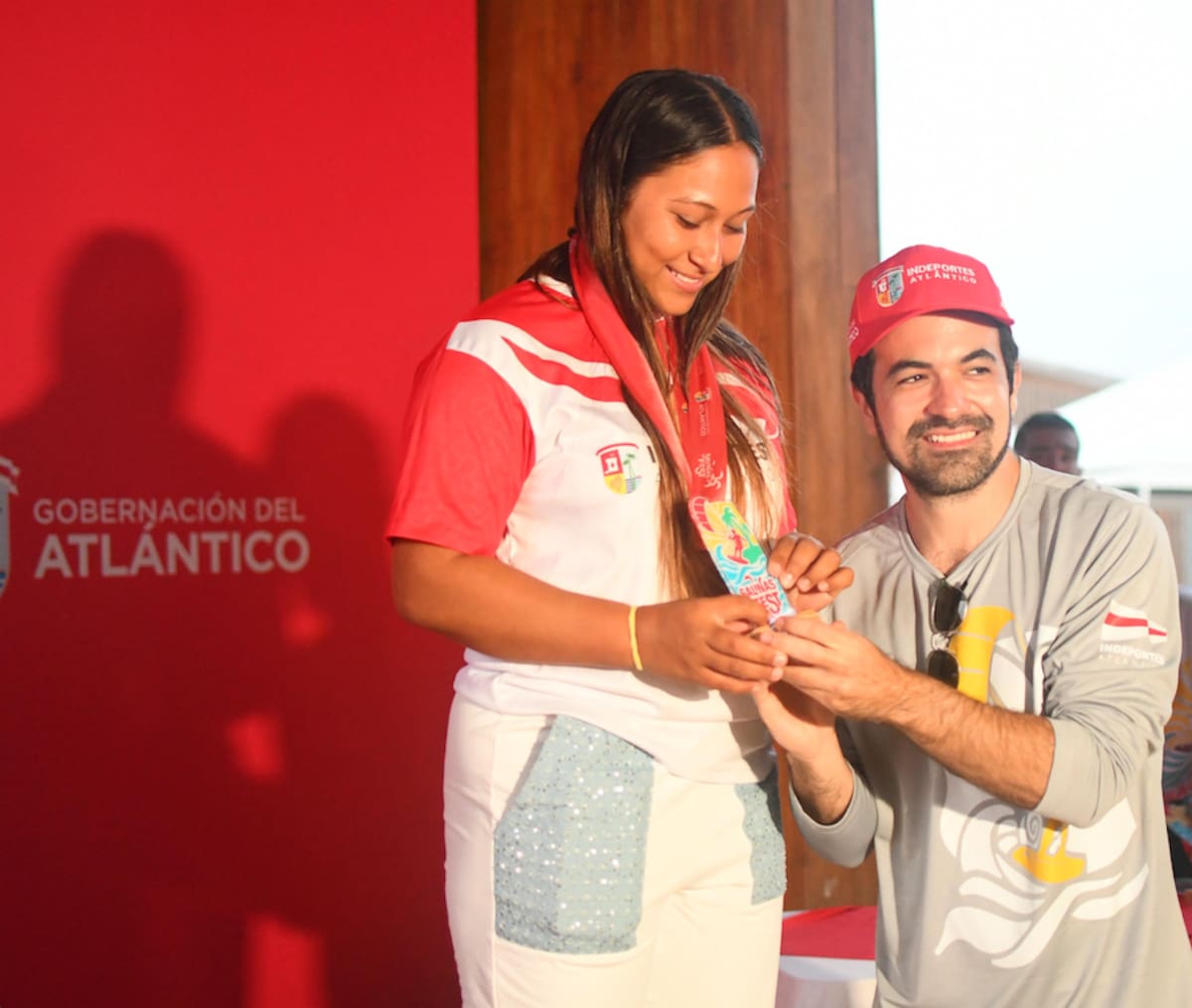 Iván Urquijo, director de Indeportes Atlántico, premia a Wendy de la Asunción, ganadora de la medalla de oro en la modalidad del Kite Foil, femenino.//Cortesía, Gobernación del Atlántico.