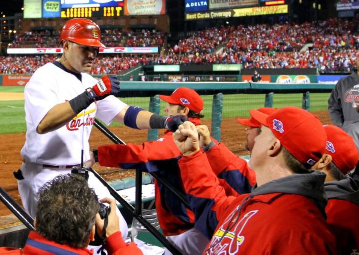 El puertorriqueño Yadier Molina es felicitado tras anotar una carrera.