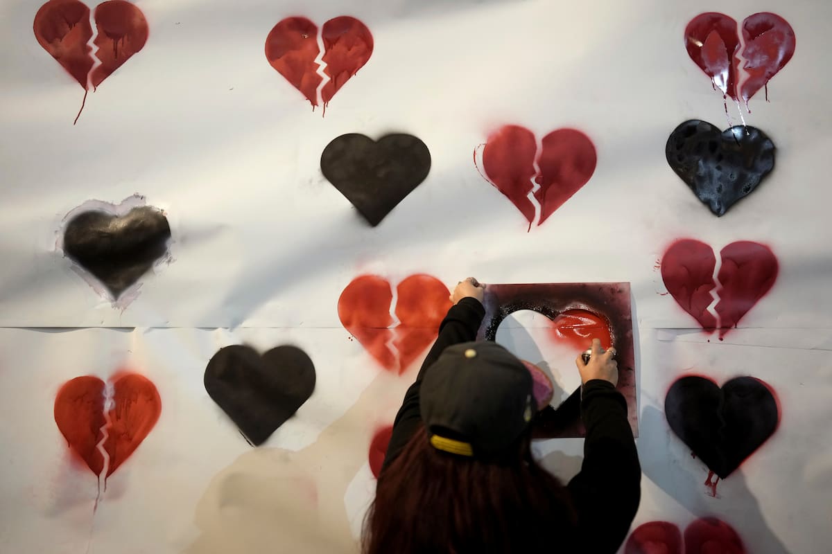 Un manifestante pinta corazones en una pancarta durante una protesta que pide la liberación de todos los rehenes cautivos por Hamas en la Franja de Gaza. // AP