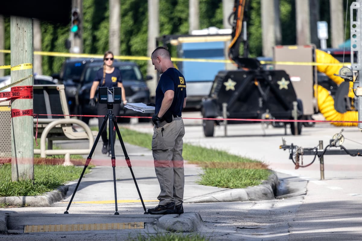 Oficiales del Sheriff de Palm Beach custodian la entrada trasera del Trump International Golf Club en West Palm Beach, Florida. //AP