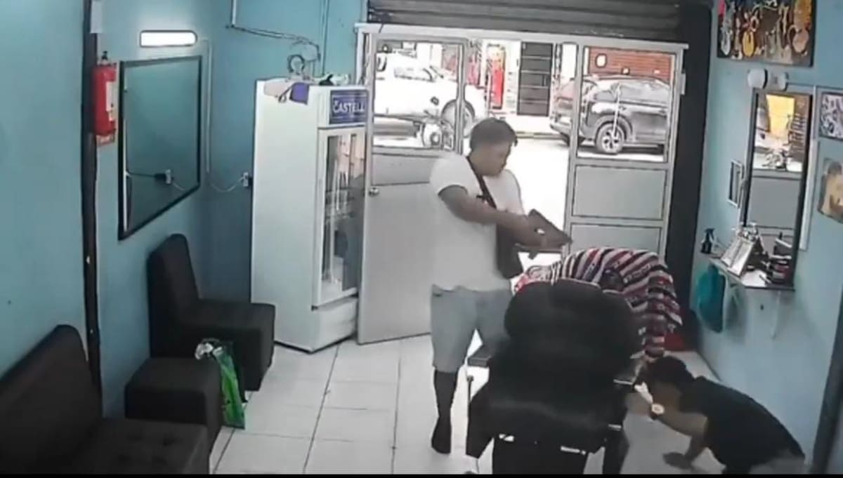 Un sicario le apunta con su arma a un barbero, pero el arma le falló. // Captura de video.