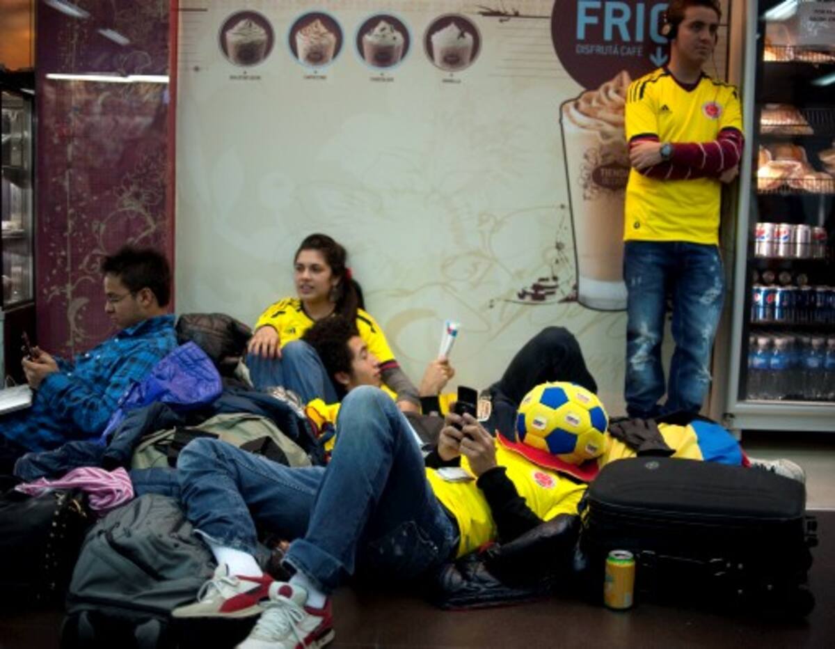 Hinchas de Colombia esperan en el aeropuerto Jorge Newbery de Buenos Aires luego de que las aerolíneas cancelaran algunos vuelos debido a la columna eruptiva. AFP JUAN MABROMATA
