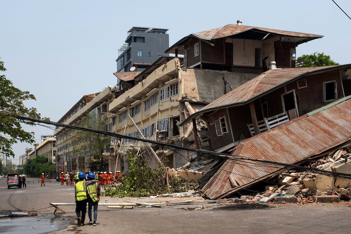 Los rescatistas caminan junto al lugar donde se derrumbó un edificio tras un terremoto en Mandalay, Myanmar. // Foto: EFE