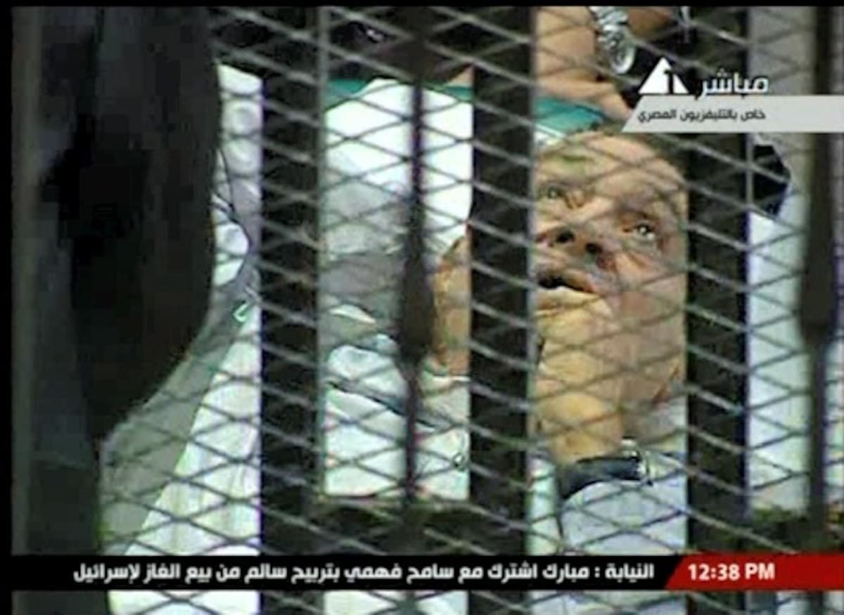 Hosni Mubarak, durante el jucio en Egipto, en una cama de hospital y detrás de un armazón de metal cubierto con tela metálica y barras de hierro. AP