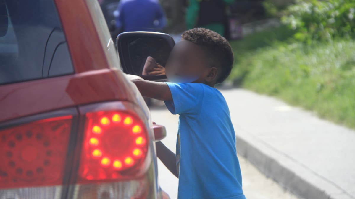 Un niño limpia los vidrios de un vehículo en Cartagena a cambio de monedas. // Foto: Archivo El Universal