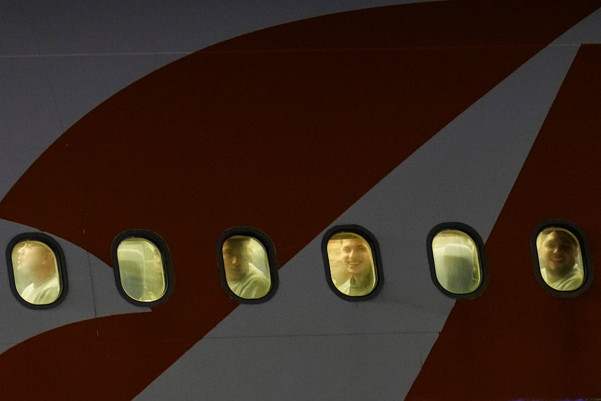 Migrantes venezolanos deportados de Estados Unidos se asoman por las ventanillas de un avión a su llegada al Aeropuerto Internacional Simón Bolívar. //AP