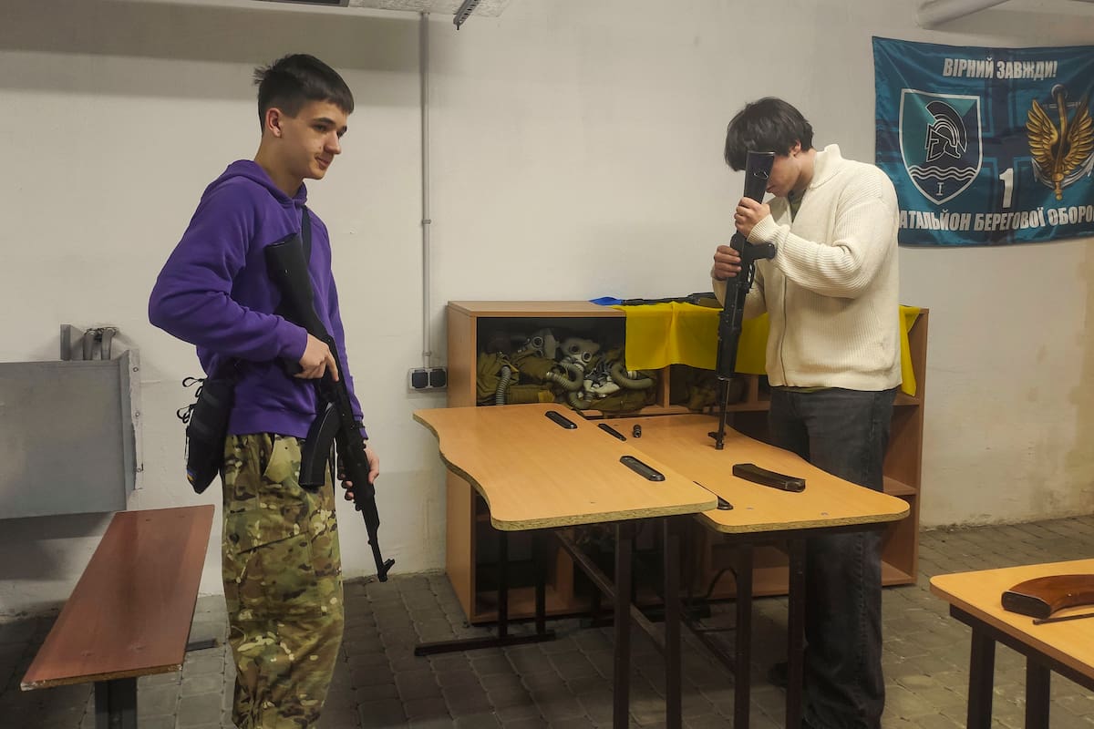 Vitali, de 16 años (i), cuyo padre sirve en el ejército, maneja con confianza réplicas de rifles y rifles neumáticos, y afirma que está listo para alistarse en el ejército si fuera necesario este jueves, en Leópolis (Ucrania). EFE/ Rostyslav Averchuk