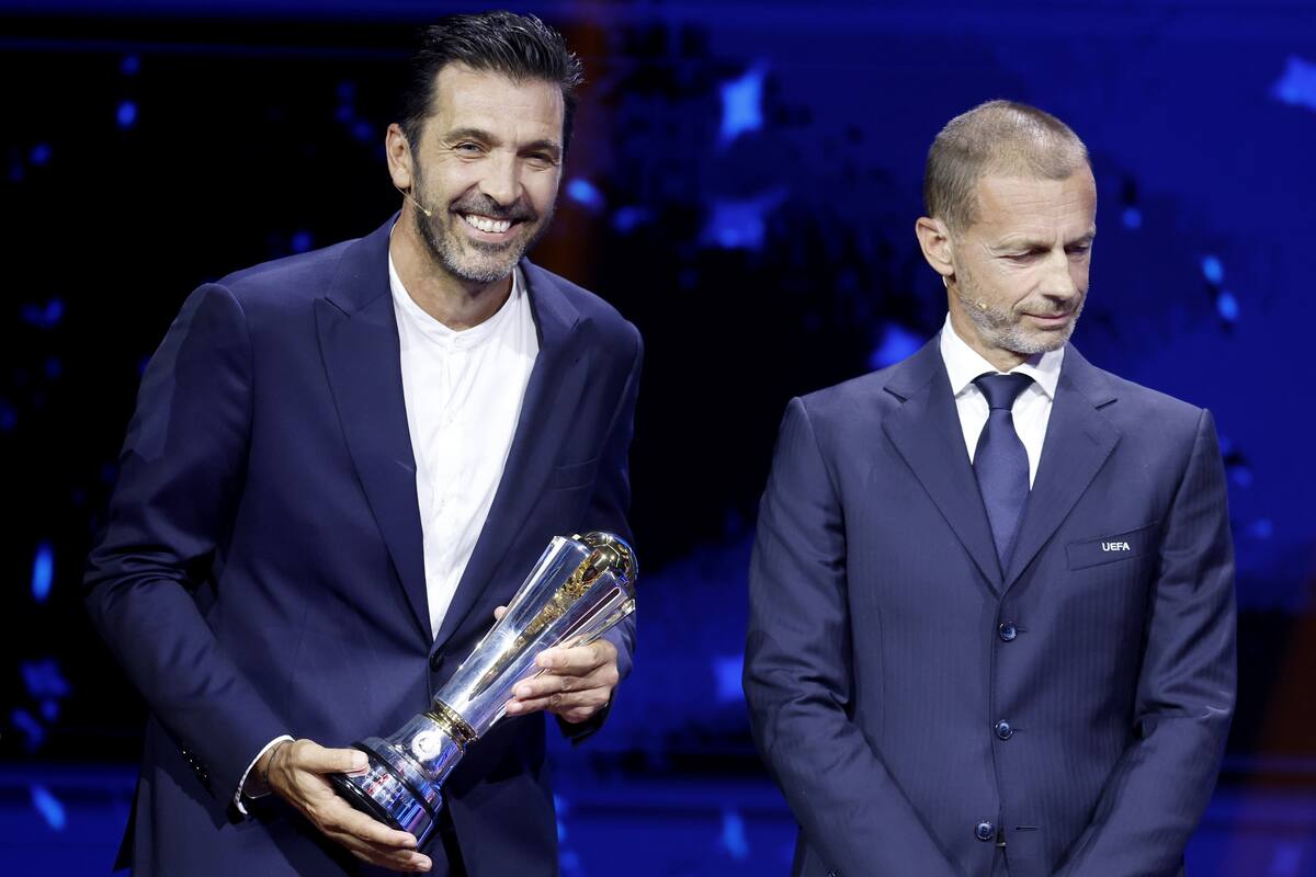El exfutbolista italiano Gianluigi Buffon (i) recibe el Premio Presidente de la UEFA 2024 de manos del presidente de la UEFA, Aleksander Ceferin, durante el sorteo de la Liga de Campeones de la UEFA en Mónaco, el 29 de agosto de 2024. //EFE