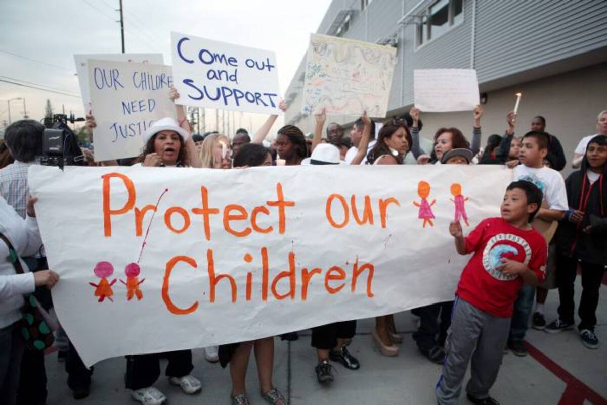 Unos 30 padres de familia y otras personas que los apoyaban protestaron frente a las puertas principales de la Escuela Primaria Miramonte en Los Angeles. AFP Krista Kennell