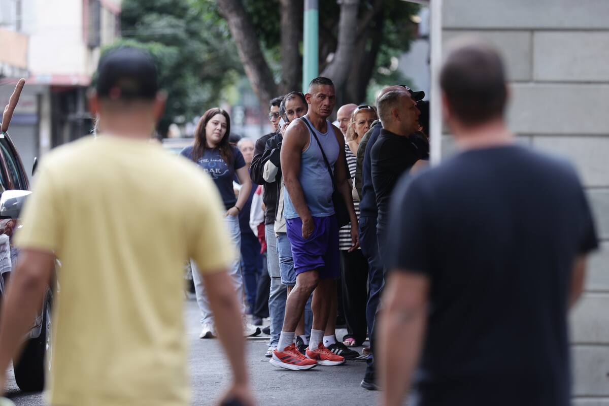 Personas hacen fila en un supermercado para abastecerse este sábado en Caracas (Venezuela). /EFE/ Ronald Peña