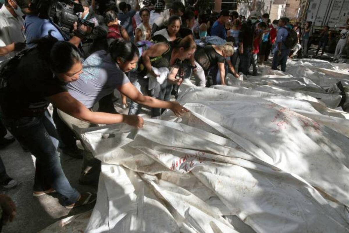 Familiares de los reos del penal hondureño ven los cuerpos sin vida de sus parientes. AP Esteban Felix